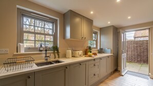 A modern kitchen with a large window, built-in cabinets, and a countertop with various appliances and items.