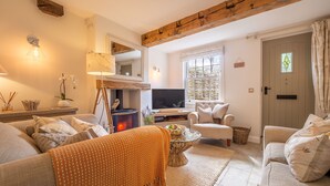 A cozy living room with a fireplace, a television, and comfortable seating. - Pond Cottage, Docking, Norfolk (Docking)