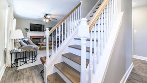 Un escalier avec des balustrades blanches et des marches en bois menant à un deuxième étage.