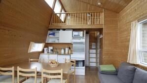 A compact kitchen with a dining area, a loft bedroom, and a sofa. - 1 bedroom stunning home in Hvide Sande (Hvide Sande)