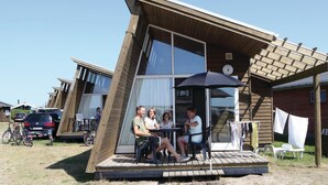 A modern wooden building with a porch, large windows, and a number '2' sign. - 1 bedroom stunning home in Hvide Sande (Hvide Sande)