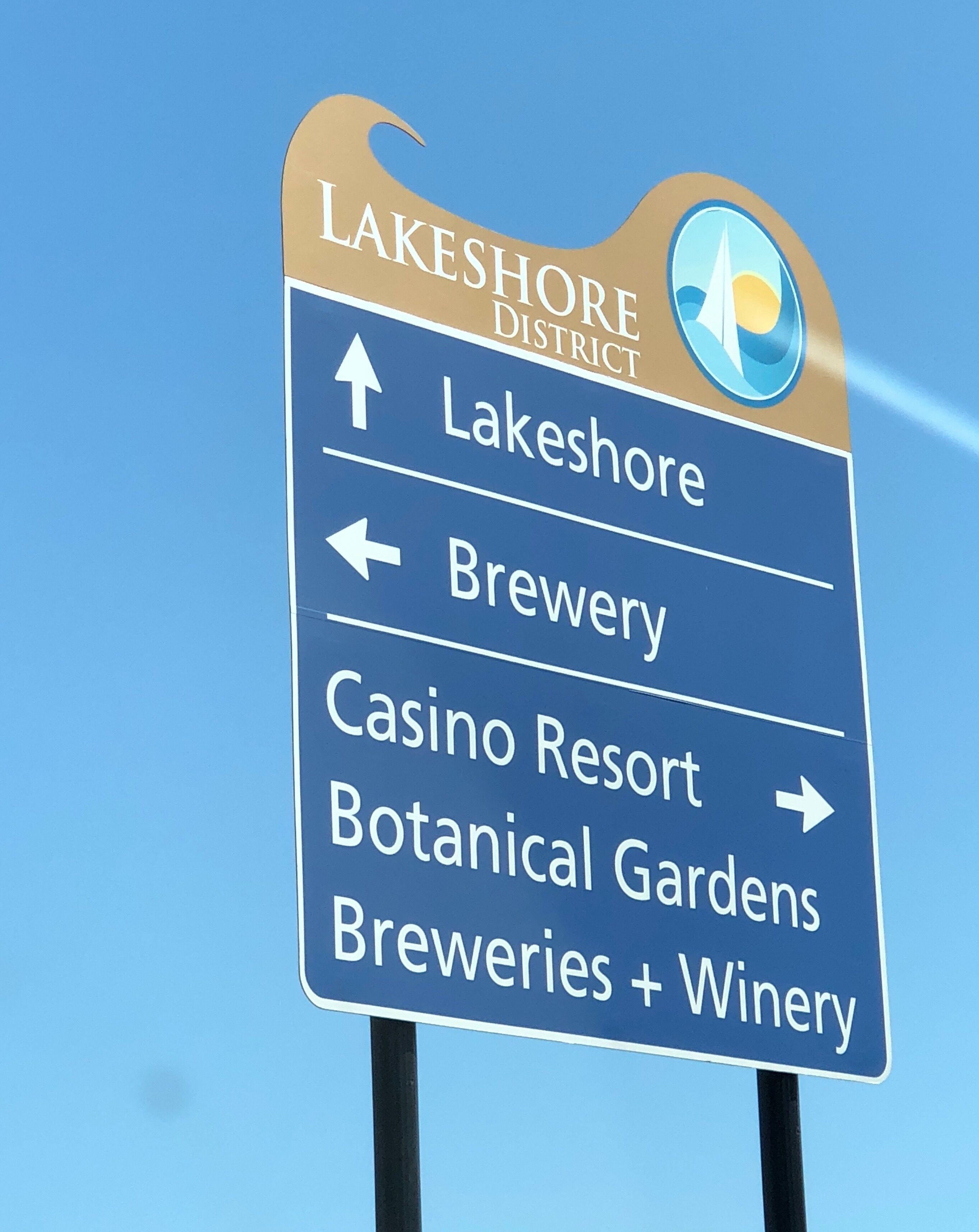Señal direccional hacia el Distrito Lakeshore, con flechas indicando Lakeshore, Fábrica de Cerveza, Casino Resort, Jardines Botánicos y Fábricas de Cerveza + Bodega.