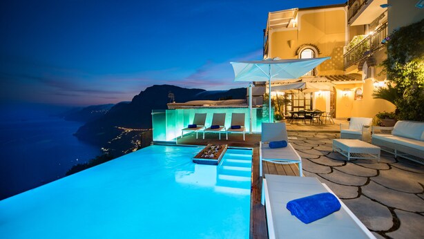 An infinity pool with a view of the coastline, outdoor seating area, and a well-lit building. - 5 Ensuite bedroom villa with pool near Positano (Positano)
