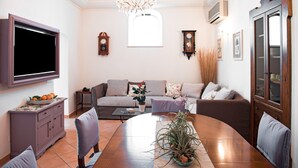 A living room with a TV, sofa, dining table, and a chandelier. - 5 Ensuite bedroom villa with pool near Positano (Positano)