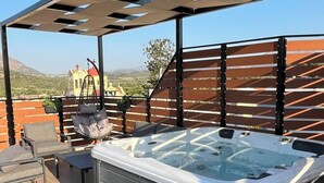 Tinaco bajo una pérgola con vistas a una iglesia y colinas.