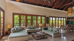 A spacious living area with large windows, comfortable seating, and a dining area.