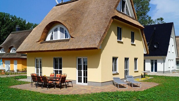 A house with a thatched roof, a yellow exterior, and a patio with outdoor furniture. - Very spacious thatched house with lots of comfort on a large plot in a peripheral location (Glowe)