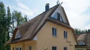 A yellow building with a thatched roof, labeled "Bastians Reethus." - Very spacious thatched house with lots of comfort on a large plot in a peripheral location (Glowe)