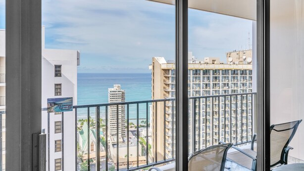 Ein Balkon mit Blick auf das Meer und die Gebäude.