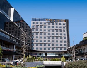 Een modern hotel met een bord waarop 'Stadia Suites' staat.