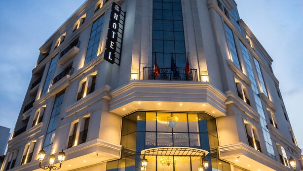 A large, multi-story hotel with a prominent entrance and a grand staircase leading up to the doors.