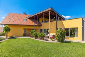 A modern house with a yellow facade, a red-tiled roof, and a covered patio area. - Villa Prleski Raj - Pool, Sauna, Jacuzzi (Križevci)