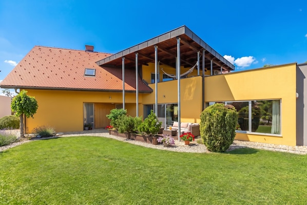 A modern house with a yellow facade, a red-tiled roof, and a covered patio area. - Villa Prleski Raj - Pool, Sauna, Jacuzzi (Križevci)