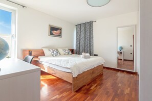 A bedroom with a wooden bed, a desk, a globe, and a large mirror. - Villa Prleski Raj - Pool, Sauna, Jacuzzi (Križevci)