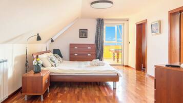 Un dormitorio con cama, mesita de noche, cómoda y vistas al exterior.