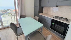 A small kitchenette with a gas stove, a sink, and a window overlooking a cityscape. - Appartamenti Borgo Panoramico N.8 (Tropea)