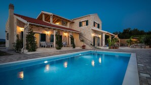 A two-story house with a swimming pool, outdoor seating, and a well-lit patio area. - Cozy home in Drnis with sauna (Drnis)
