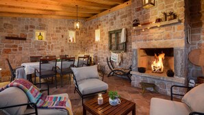 A cozy stone-floored room with a fireplace, wooden beams, and rustic decor. - Cozy home in Drnis with sauna (Drnis)