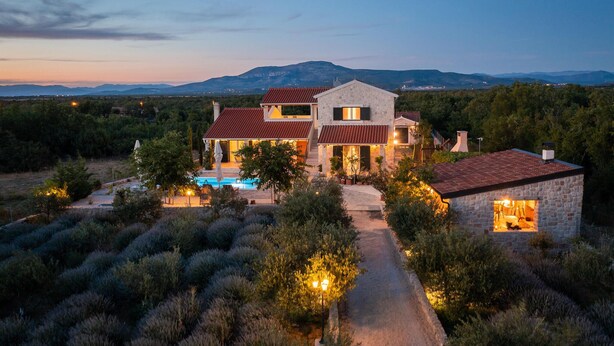 A two-story stone house with a swimming pool, surrounded by olive groves and a mountainous backdrop. - Cozy home in Drnis with sauna (Drnis)