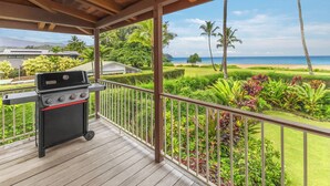 A covered outdoor area with a grill and a view of a beach and ocean. - Oceanfront Hanalei Bay home - Hanalei Surf (Hanalei)