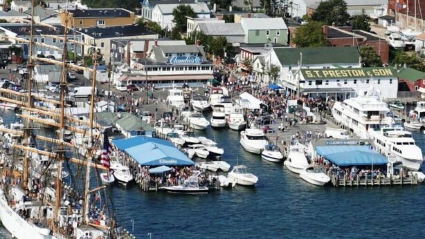 A busy harbor with numerous boats docked, a large ship with multiple decks, and a building with 'S.T. Preston & Son' signage. - NEW VICTORIAN GEM IN GREENPORT (Greenport)