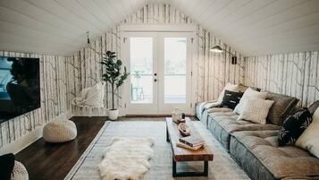 TV connectée, cheminée, table de tennis de table, livres