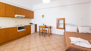 A compact room with a kitchenette, a single bed, and a small table with a chair. - Maria's Place, a great place to experience Crete! (Rethymno)