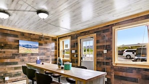 Un salón de conferencias con una mesa de madera, sillas y un amplio ventanal.