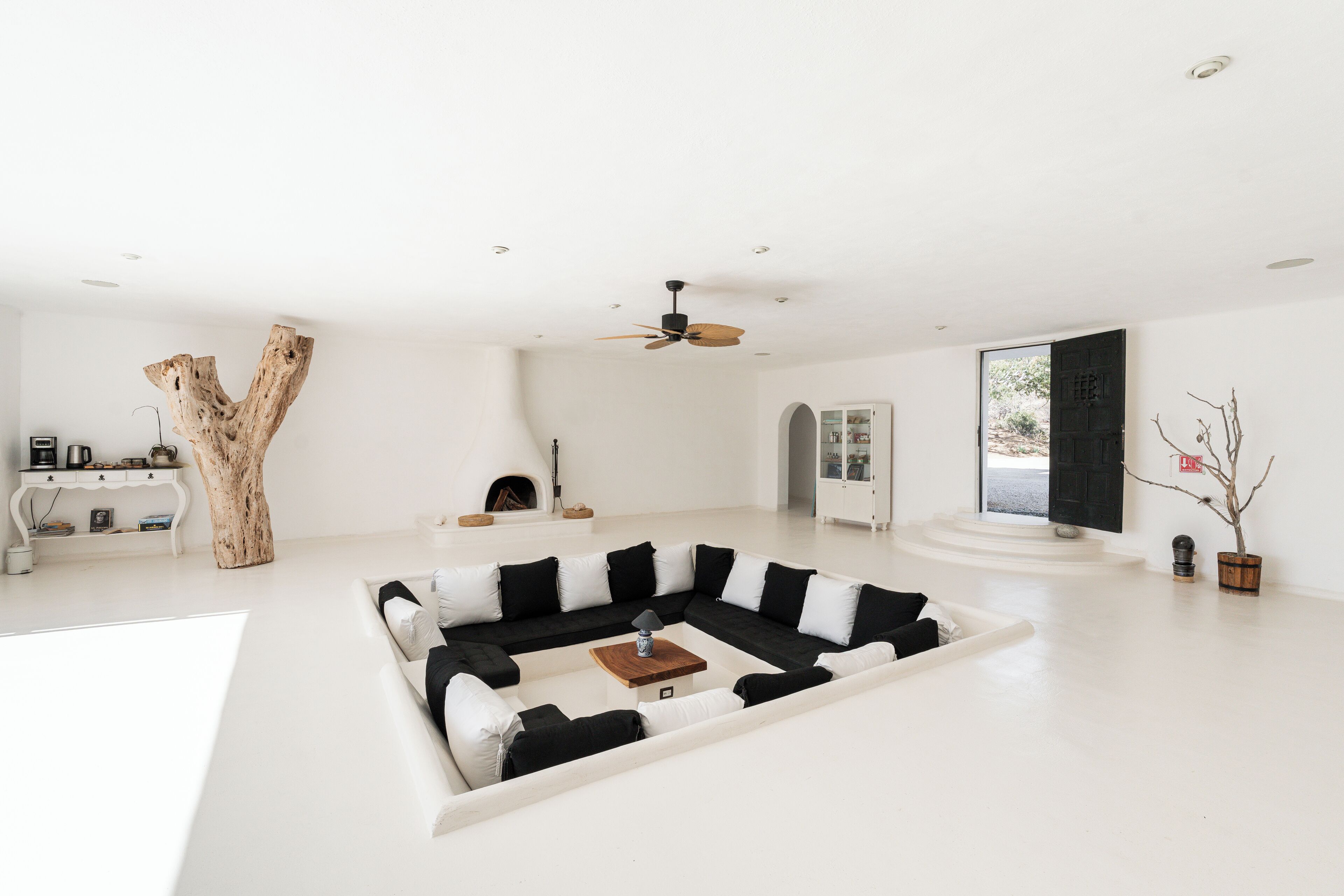 A spacious living room with a large sectional sofa, a wooden coffee table, and a ceiling fan.