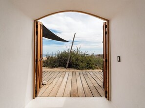 A wooden deck leading to a beach with a view of the sea and sky. - NEST Baja, Member of Design Hotels (La Fortuna)