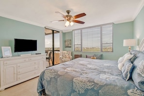 A bedroom with a bed, a television, a ceiling fan, and a window with blinds. - 18120 San Carlos Blvd PH2 (Fort Myers Beach)