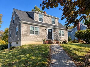 A two-story house with a front porch, a driveway, and a well-maintained lawn.