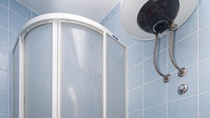 Een badkamer met een douchecabine, toilet en een handdoekhouder.