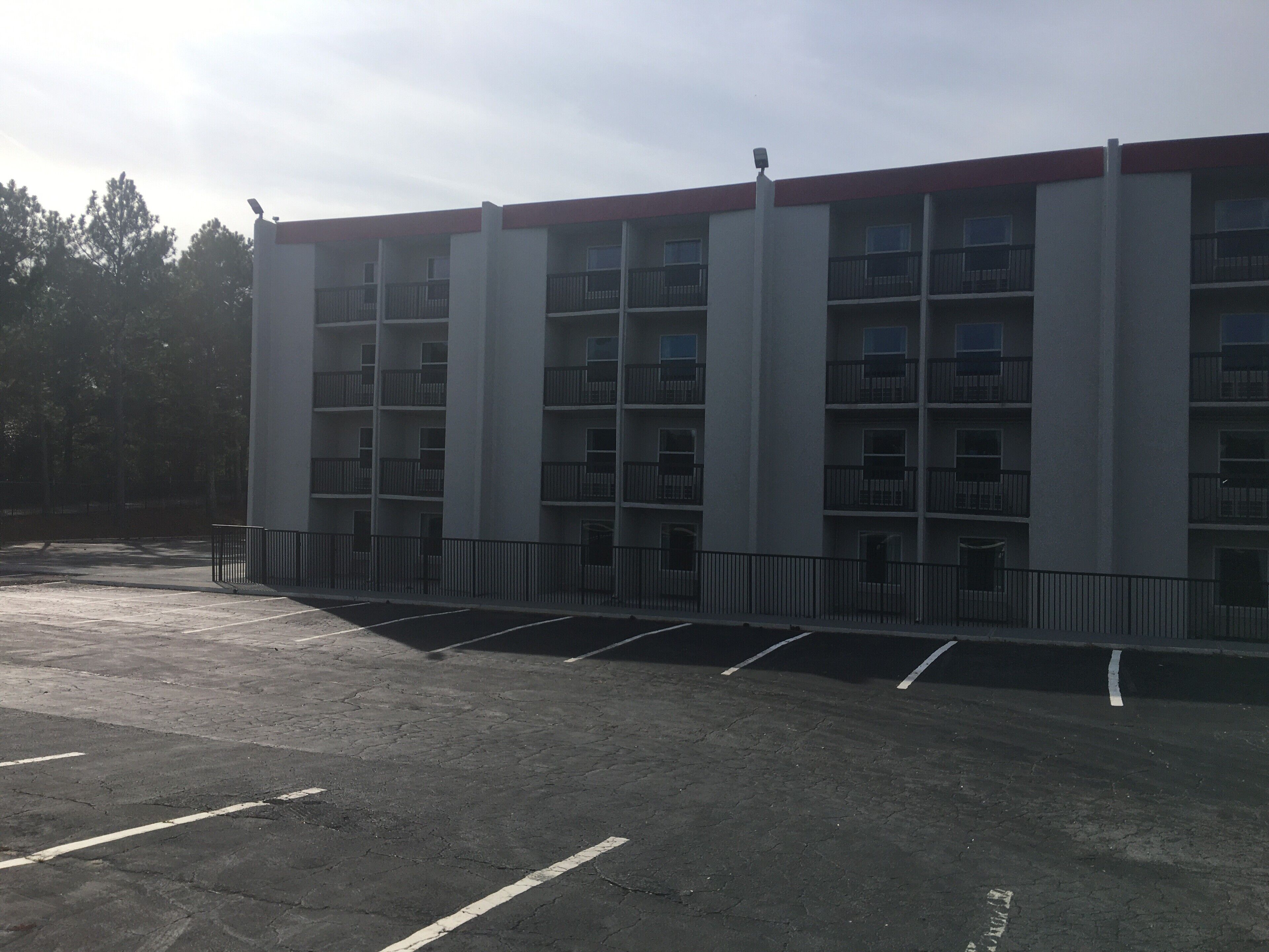 A multi-story parking garage with a red roof and multiple balconies.