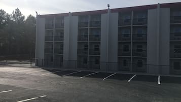 A multi-story parking garage with a red roof and multiple balconies.