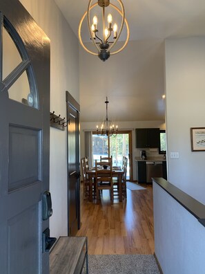A modern kitchen with dark cabinets, a stainless steel dishwasher, and a large window.