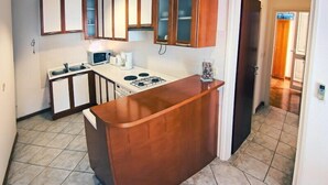 Une cuisine avec des armoires en bois, un plan de travail, un four à micro-ondes et une cuisinière.