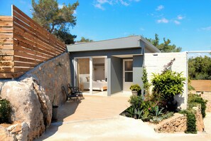 A modern house with a patio, a bed, and a dining area. - Canes Villa Heated Pool (Agios Nikolaos)