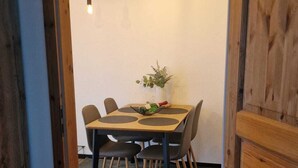 A wooden-framed doorway leading to a dining area with a table, chairs, and a potted plant. - Studio "ton Barkenboom" (Esens)