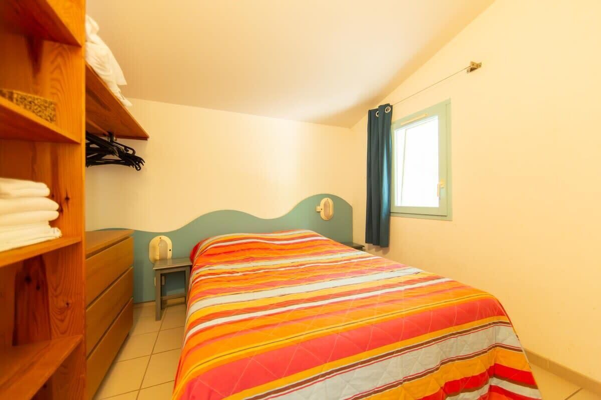 Ein Schlafzimmer mit einem Bett, einem Holzschrank und einem kleinen Nachttisch.