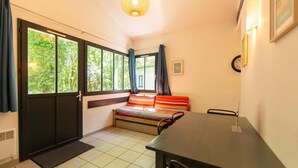 A room with a bed, a desk, and large windows. - Maisonnette St Brice 44 for 5 persons (Arès)