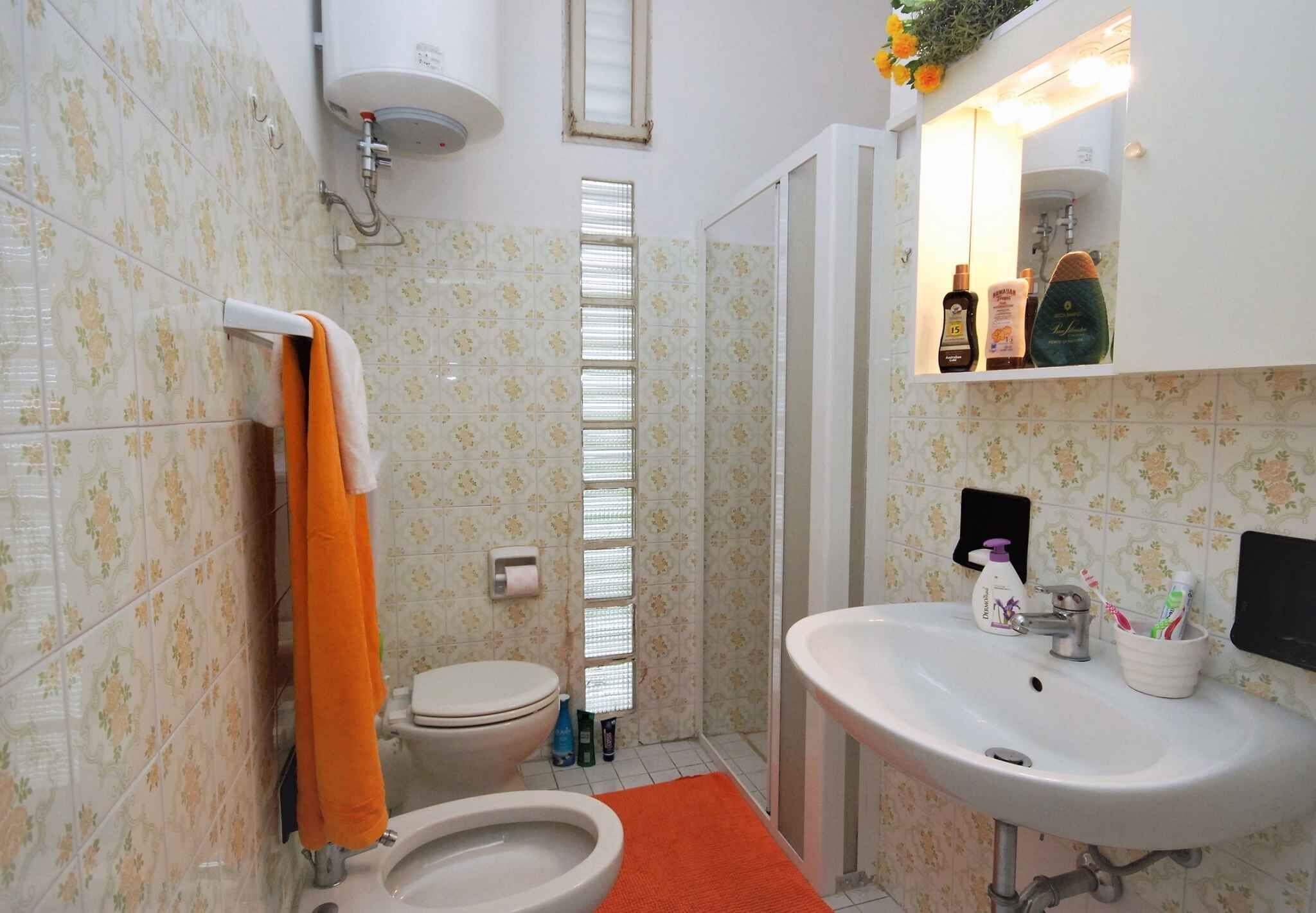 A bathroom with a toilet, sink, and shower.