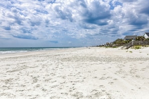 A beach with a wooden staircase leading to a house, a clear sky, and the ocean. - Heaven Can Wait - Oceanfront w/ Heated Pool and Sooo Much More! (Garden City Beach)