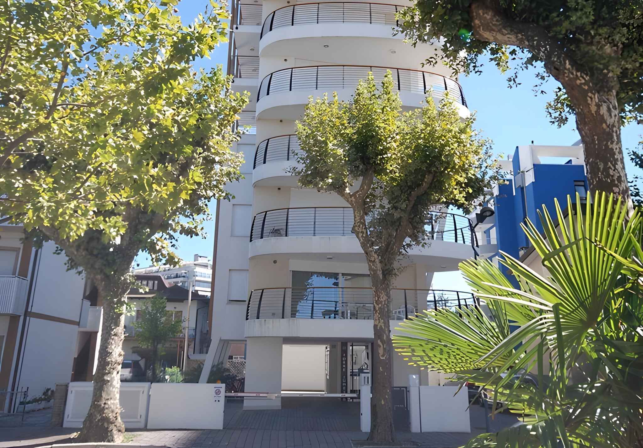 A multi-story residential building with balconies and a gated entrance.