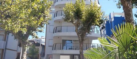 A multi-story residential building with balconies and a gated entrance.