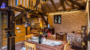 A rustic wooden interior with a dining area, wooden beams, and a stone wall. - Lazuština Paradise - Holiday Home with Swimming Pool (Gruda)