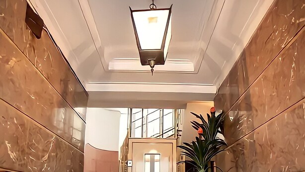 A marble-floored staircase leading to a door with a light fixture above. - "House of Joy" Apartment (Porto)