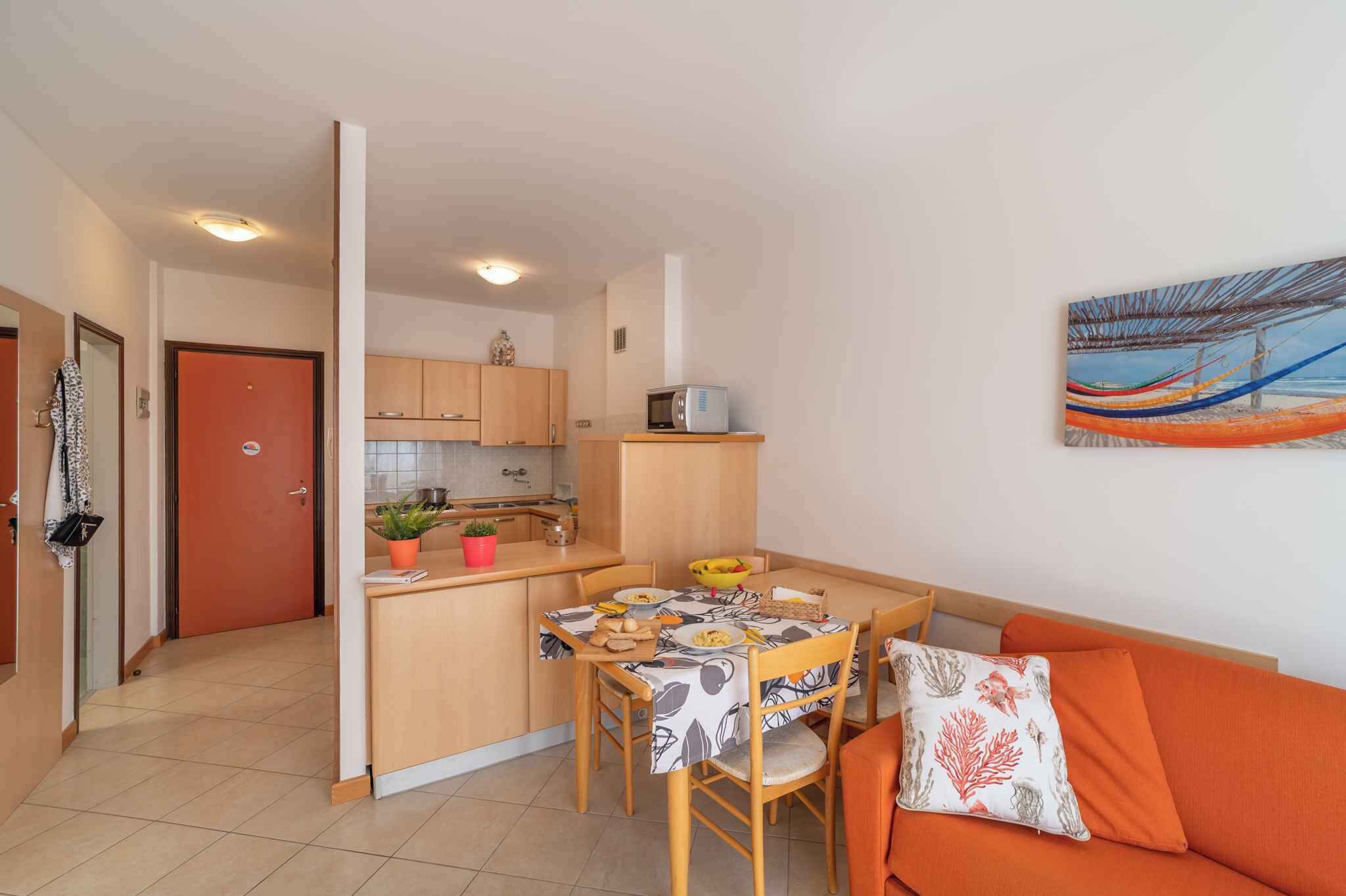 A compact living space with a kitchenette, a dining area, and a sofa.