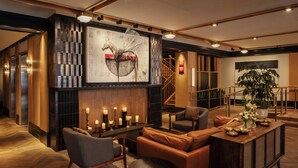 A modern lobby with a fireplace, seating area, staircase, and a large abstract painting. - Clayton Hotel & Members Club - Cherry Creek, Denver (Denver)
