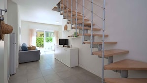 A modern apartment with a staircase, a living area with a sofa, a kitchen, and a balcony with a view. - Holiday apartment with air conditioning (Lignano)